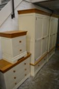 A good modern oak and cream painted bedroom suite comprising pair of wardrobes, chest of drawers and