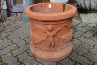 A large circular terracotta plant pot with moulded decoration.