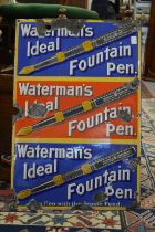An enamel sign 'Watermans Ideal Fountain Pen', three rows of text and images in blue, red and blue.