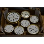 A brass ships clock and six similar brass circular bedside/mantle clocks.