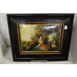 A classical style painting on metal depicting figures picnicking beneath a tree in an ebonised