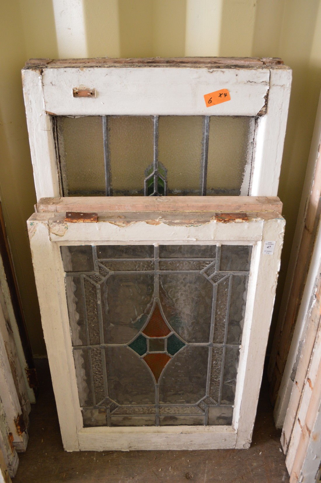 Two large and two small framed leaded lights with stained glass decoration.
