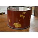 A Japanese circular lacquer container housing dry flower arrangement.