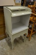 A green painted bedside cupboard.