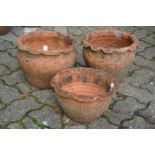 A pair of terracotta plant pots with wavy rims and a similar smaller plant pot.