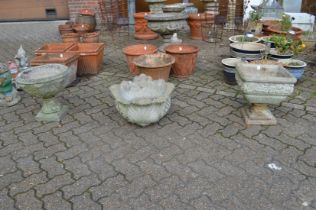 Two reconstituted stone pedestal planters and a similar planter lacking base.
