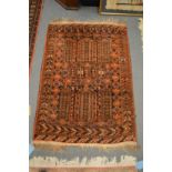 A small Persian rug, rust ground with stylised decoration, 130cm x 88cm.