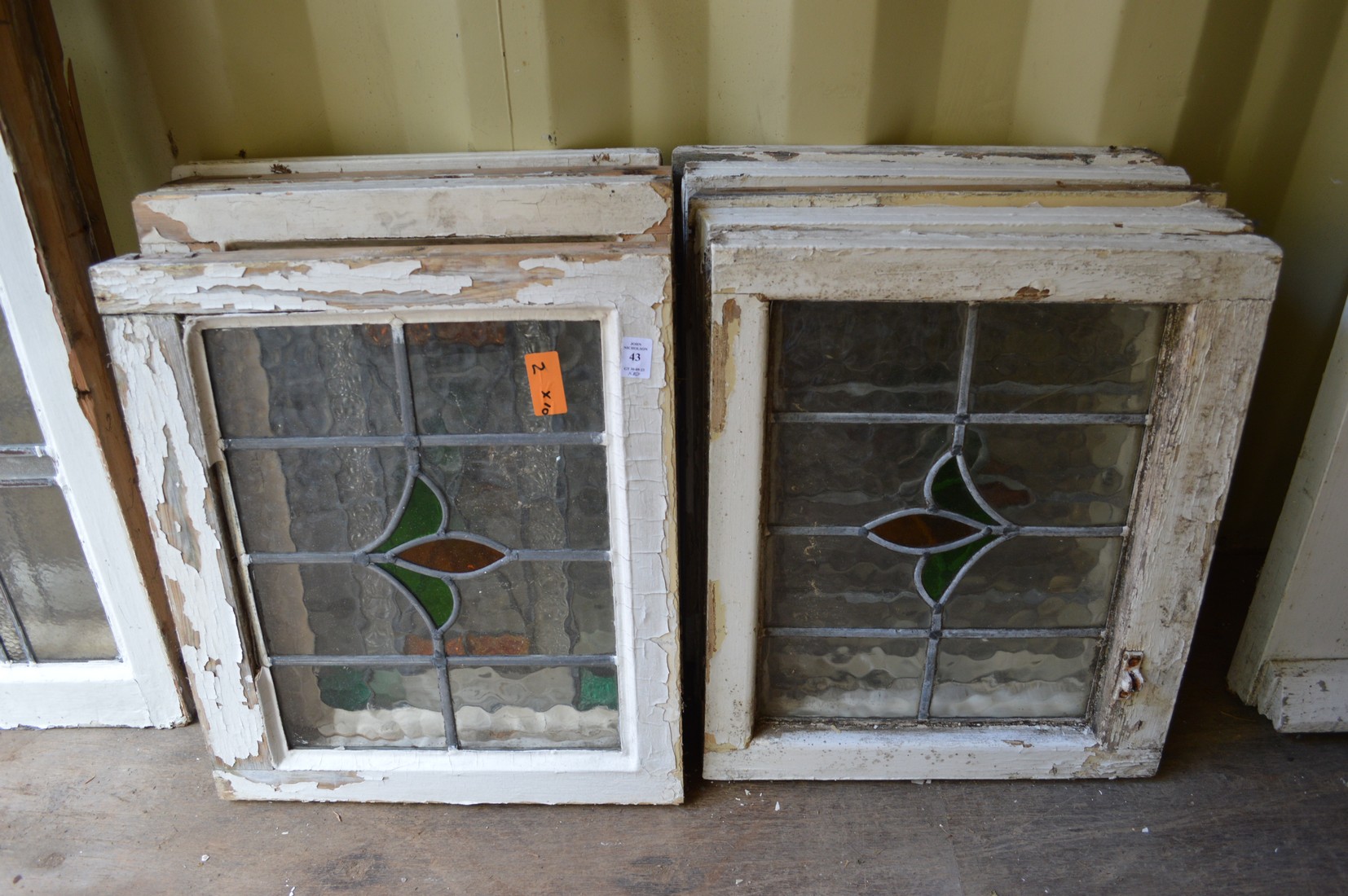 Ten small framed leaded lights with stained glass decoration.