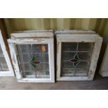 Ten small framed leaded lights with stained glass decoration.