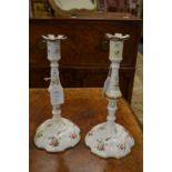 A pair of early 19th century enamel candlesticks with floral decoration.