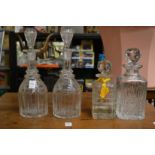 A pair of cut glass decanters and two whisky decanters.