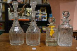 A pair of cut glass decanters and two whisky decanters.