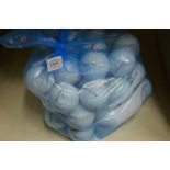 A bag of fifty Taylor Made golf balls.