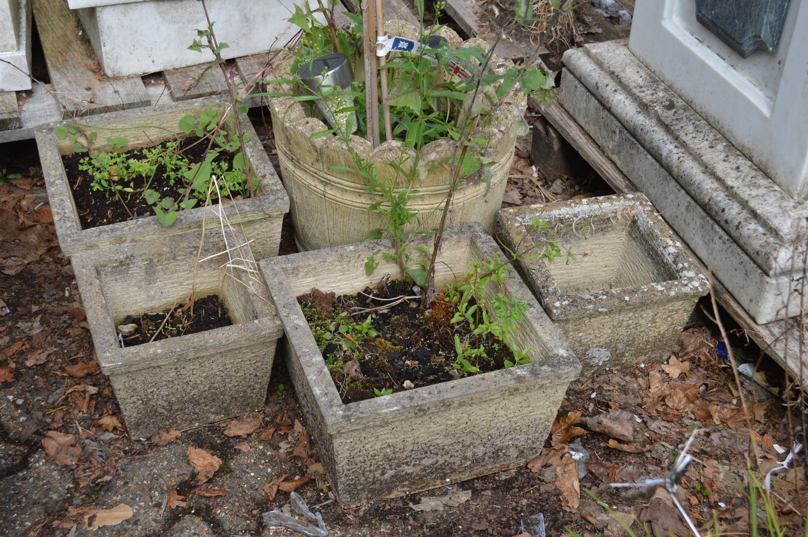 A reconstituted stone planter and four smaller square planters.