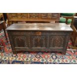 An 18th century oak coffer with plain plank top and carved triple panelled front.