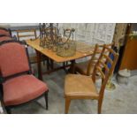 A teak drop leaf gateleg dining table and four chairs.