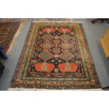 A good Persian design carpet, blue ground with stylised panels, within a similar border, 190cm x