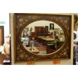 A rectangular mirror with oval shaped mirror plate, the frame with hand painted floral decoration.