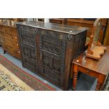 An 18th century and later carved oak two door cupboard.