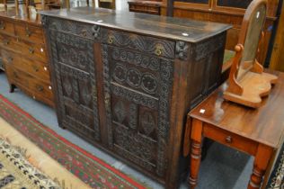 An 18th century and later carved oak two door cupboard.