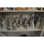 A group of Lladro, Nao and similar figures.