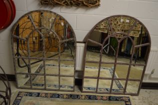 A pair of arch shaped metal window form mirrors.