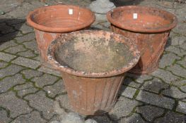A pair of terracotta plant pots and a similar pot.