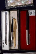 A boxed Parker fountain pen and three other pens.