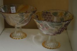 A pair of colourful glass pedestal bowls.