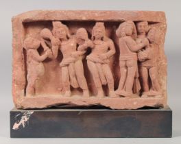 AN INDIAN MATHURA KUSHAN RED STONE CARVED PANEL, depicting kings and aprsa, with mounted base, panel