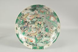 A CHINESE FAMILLE VERTE PORCELAIN DISH, decorated with figures on horseback, 29cm diameter.
