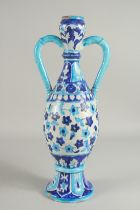 AN ISMALMIC BLUE AND WHITE GLAZED POTTERY VASE, with twin handles, 44.5cm high.