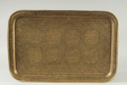 A LARGE 19TH CENTURY PERSIAN QAJAR ENGRAVED BRASS TRAY, decorated with eight panels depicting