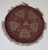 AN OTTOMAN GILT METAL THREADED RED VELVET CIRCULAR TEXTILE, embroidered with mosques, 81cm
