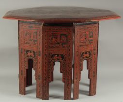 A LARGE BURMESE RED AND BLACK LACQUERED WOOD OCTAGONAL TABLE, with hinged folding legs, 82cm at