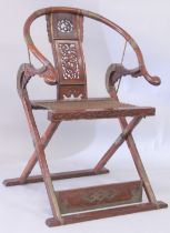 A CHINESE HARDWOOD HORSESHOE-BACK FOLDING CHAIR, with carved and pierced kylin panel and netted