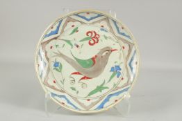 AN OTTOMAN TURKISH IZNIK GLAZED POTTERY PLATE with bird, 30.5cm diameter.