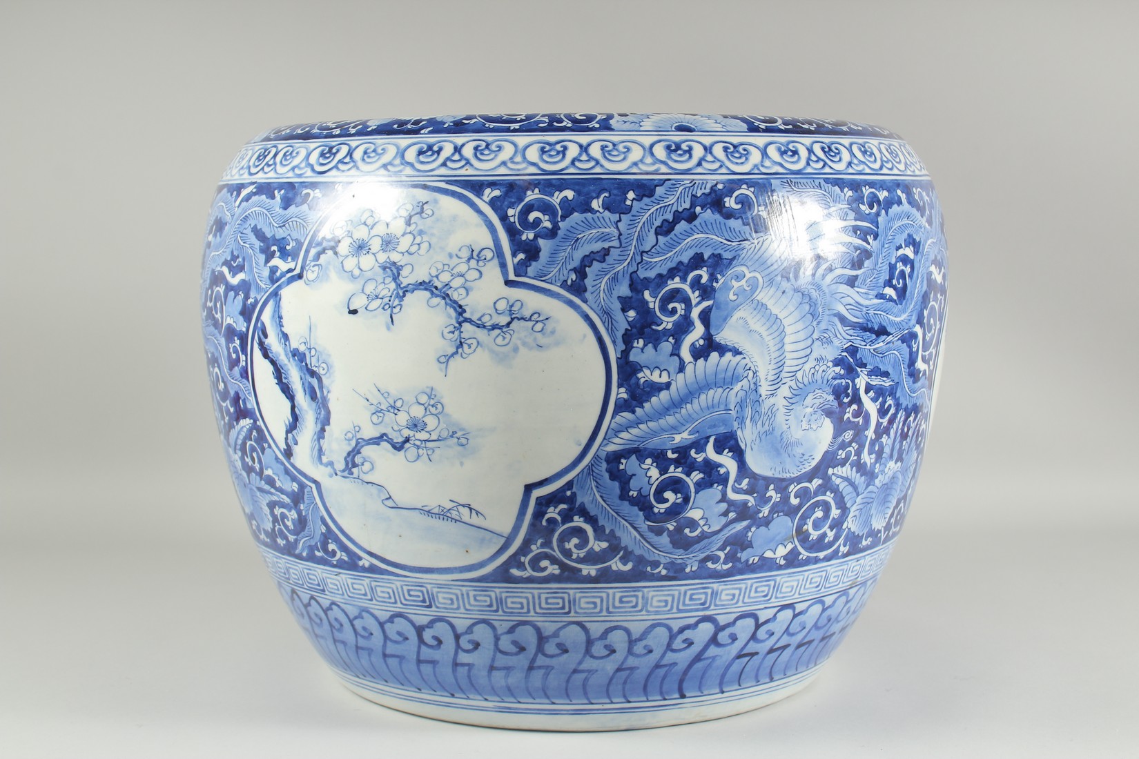 A LARGE BLUE AND WHITE PORCELAIN JARDINIERE, painted with phoenix and panels of flora, (af), 45cm - Image 3 of 5