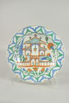 AN OTTOMAN TURKISH IZNIK GLAZED POTTERY PLATE with mosque, 31.5cm diameter.