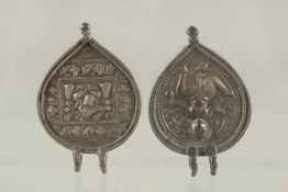 TWO 19TH CENTURY INDIAN SILVER PENDANTS, one depicting Ganesh, the other depicting another deity,