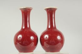A PAIR OF CHINESE SANG DE BOEUF PORCELAIN BOTTLE VASES, each with character mark to base, 16cm