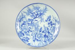A LARGE JAPANESE BLUE AND WHITE PORCELAIN CHARGER, decorated with a bird in a tree and flora, 46.5cm