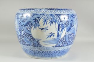 A LARGE BLUE AND WHITE PORCELAIN JARDINIERE, painted with phoenix and panels of flora, (af), 45cm