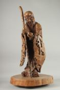 A VERY LARGE AND FINE WOOD CARVING OF SHAO LOU, mounted to a natural tree trunk base, the figure