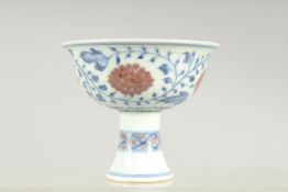 A SMALL CHINESE BLUE, WHITE AND UNDERGLAZE RED PORCELAIN STEM CUP, decorated with flower heads and