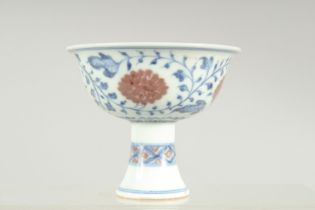 A SMALL CHINESE BLUE, WHITE AND UNDERGLAZE RED PORCELAIN STEM CUP, decorated with flower heads and