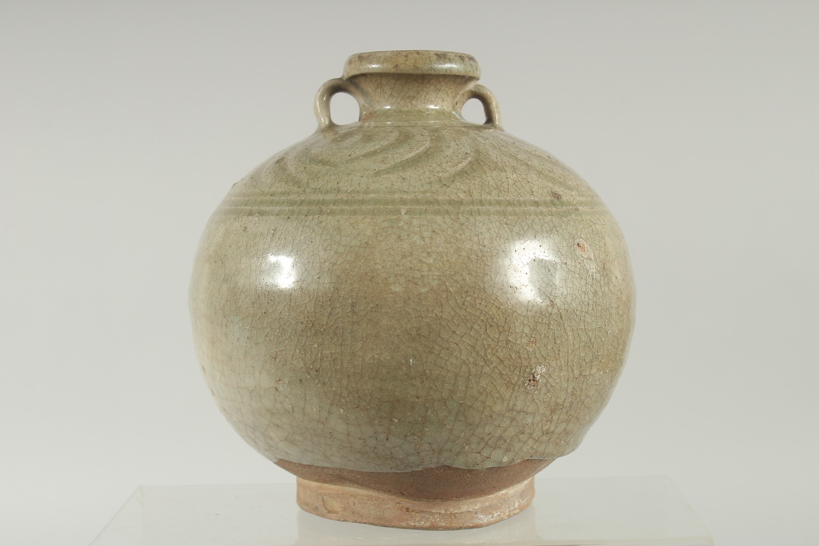 A CELADON GLAZED POTTERY TWIN HANDLE BOTTLE / VASE, with carved decoration to the shoulder, 16cm