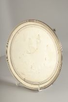 A GEORGE III SILVER CIRCULAR SALVER. 8ins diameter with reeded edge, on three curving feet.London