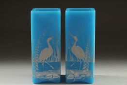 A GOOD PAIR OF AESTHETIC TURQUOISE GLASS, SQUARE VASES with storks in relief. 6.5ins high.