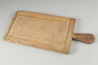 A PALE OAK CHOPPING BOARD. 21ins long.